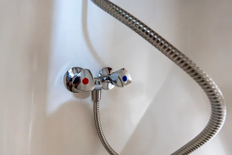 Slide: The Image of Chrome shower controls with red and blue indicators on a Kadey-Krogen 42, 1991 model. - 21