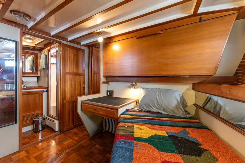 Slide: The Image of Cozy 1991 Kadey-Krogen 42 cabin interior with wooden furnishings and colorful bedding. - 13