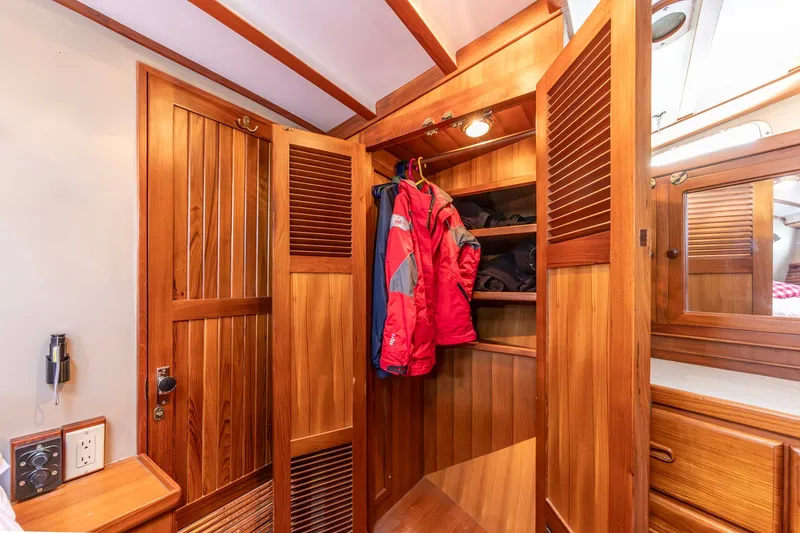 Slide: The Image of Wooden interior of 1991 Kadey-Krogen 42 yacht with open closet and hanging jackets. - 19