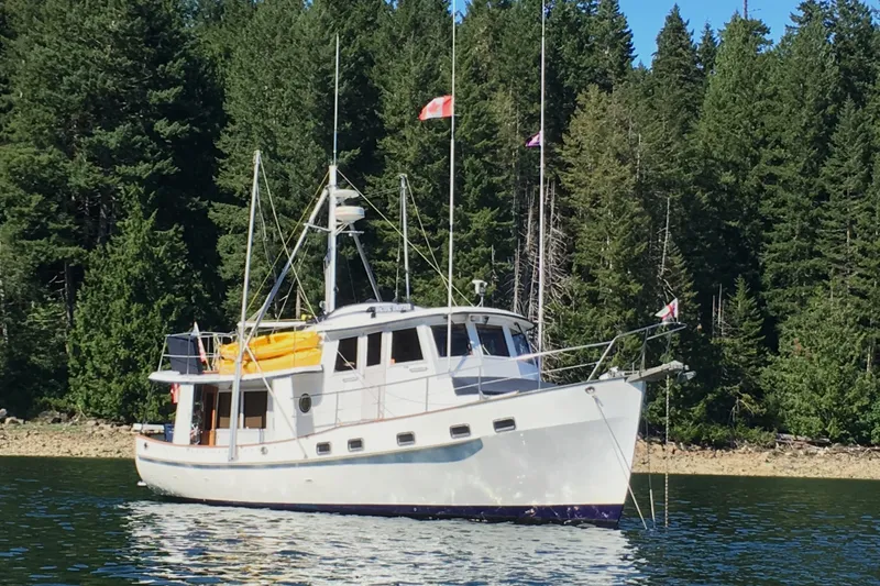 The Image of Kadey-Krogen 42 yacht from 1991 anchored near a forested shoreline. - 0