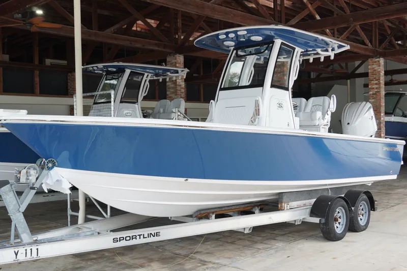 The Image of 2027 Sportsman Masters 247OE Bay Boat in blue on trailer, indoor showroom. - 0