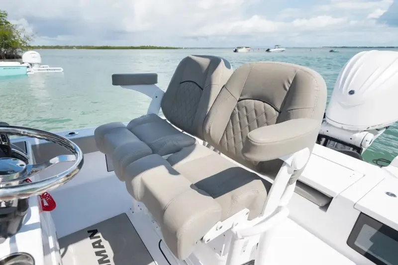Slide: The Image of 2027 Sportsman Masters 247OE Bay Boat with comfortable seating, steering wheel, and scenic ocean view. - 4