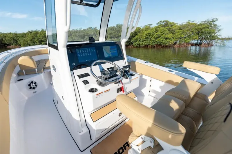 Slide: The Image of 2027 Sportsman Masters 247OE Bay Boat interior with modern helm and seating, near lush mangroves. - 1