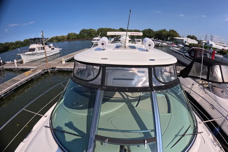 Slide: The Image of 2007 Sea Ray 44 Sundancer yacht docked at a marina under clear blue skies. - 16