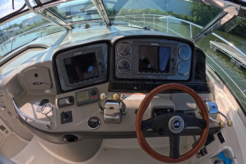Slide: The Image of 2007 Sea Ray 44 Sundancer helm with dual displays and wooden steering wheel. - 23
