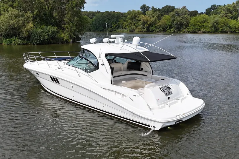 Slide: The Image of 2007 Sea Ray 44 Sundancer yacht cruising on a serene lake surrounded by lush greenery. - 1