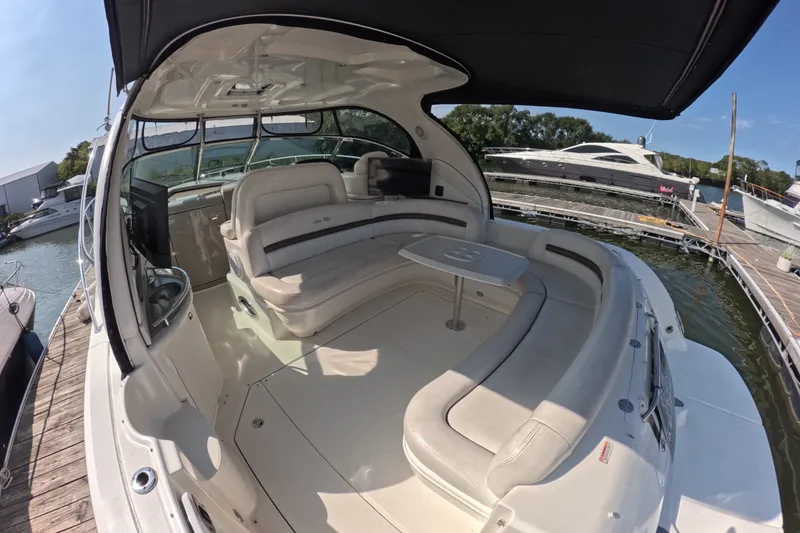 Slide: The Image of 2007 Sea Ray 44 Sundancer yacht interior with spacious seating and table at marina. - 6