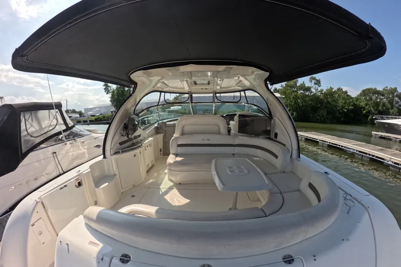 Slide: The Image of 2007 Sea Ray 44 Sundancer yacht interior with seating and table, docked by the water. - 4
