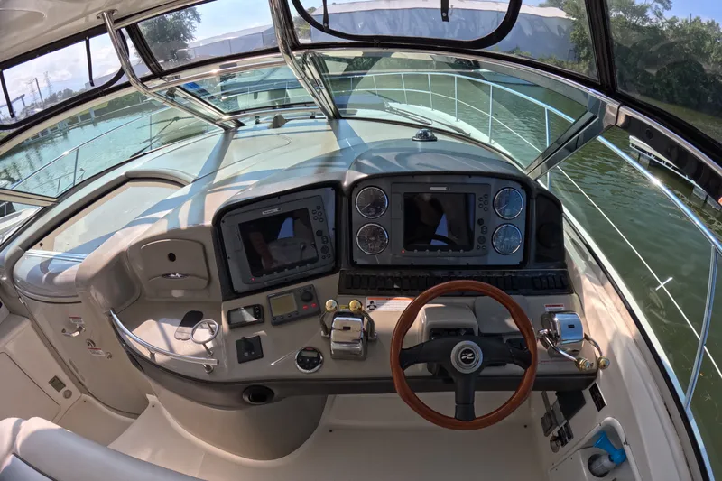 Slide: The Image of 2007 Sea Ray 44 Sundancer helm with modern navigation equipment and wooden steering wheel. - 24