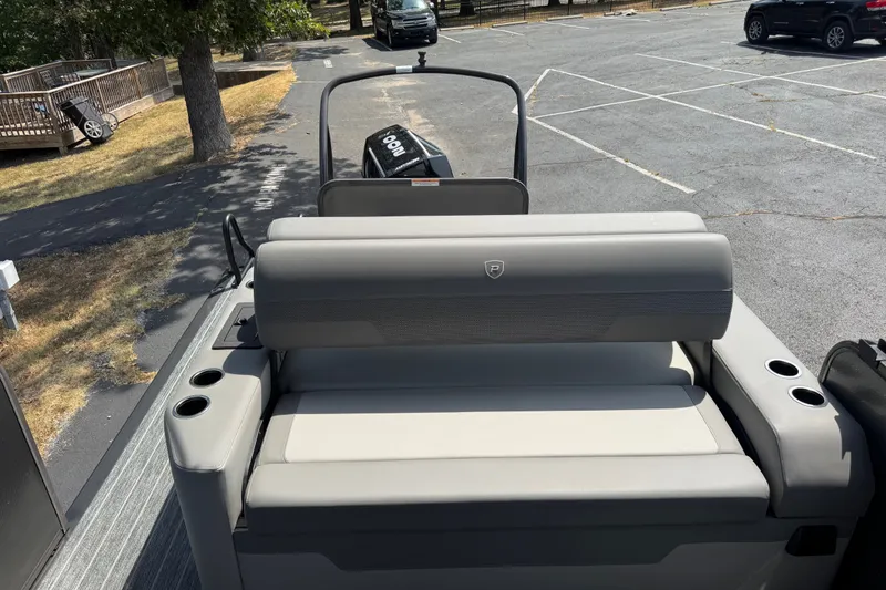 Slide: The Image of 2027 Premier 230 Sunsation RL - CL boat with gray seating and cup holders in a parking lot. - 9