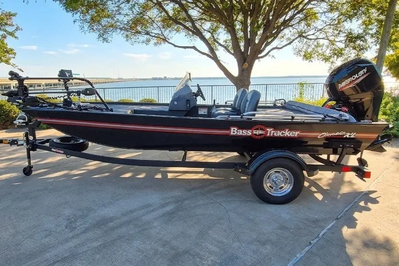 The Image of 2026 Tracker Bass Tracker Classic XL boat on trailer by a lakeside. - 0