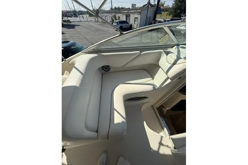 Slide: The Image of Interior seating of a 2000 Sea Ray 240 Sundancer boat, featuring cream upholstery. - 14