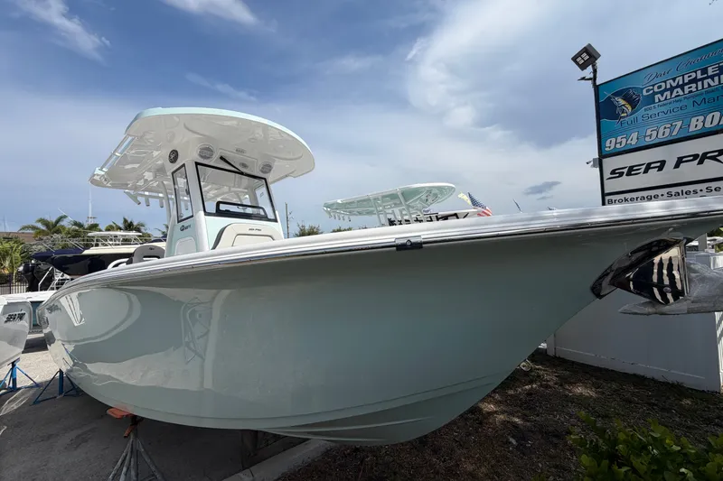 Slide: The Image of 2026 Sea Pro 245FLXR Sandbar boat displayed at a marina under a clear sky. - 2