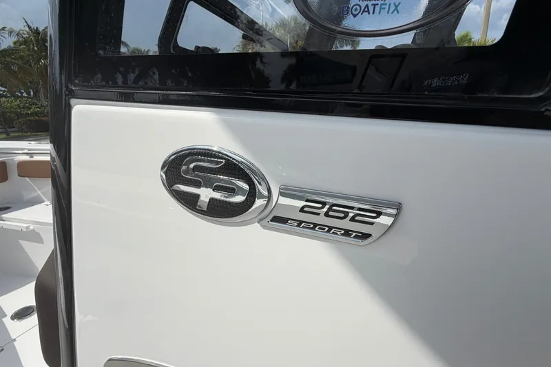 Slide: The Image of 2027 Sea Pro 262 DLX boat emblem on white exterior. - 4