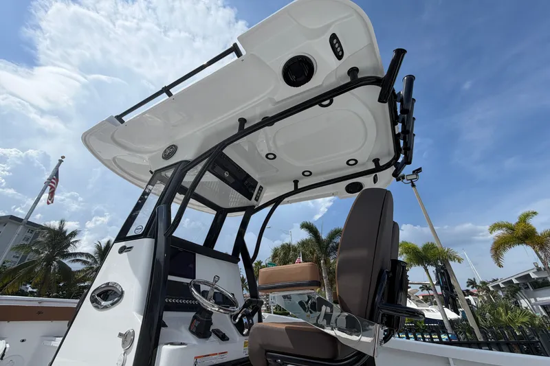 Slide: The Image of 2027 Sea Pro 262 DLX boat console with seating, under a clear blue sky. - 12