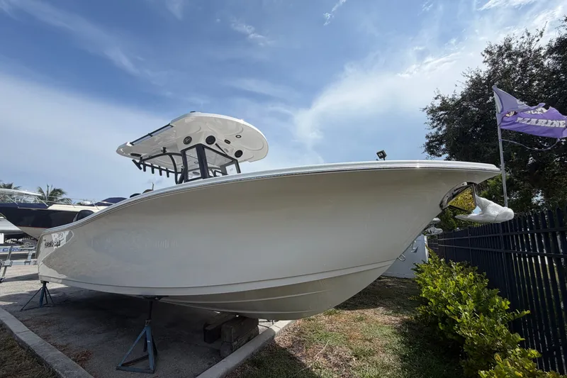 Slide: The Image of 2027 Sea Pro 262 DLX boat displayed outdoors under a clear sky. - 2
