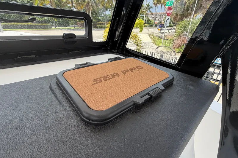 Slide: The Image of 2027 Sea Pro 262 DLX boat interior with branded hatch cover, tropical background. - 27