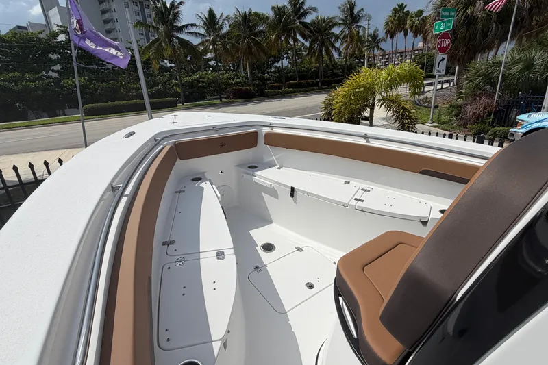 Slide: The Image of 2027 Sea Pro 262 DLX boat interior with seating, palm trees, and street view. - 15