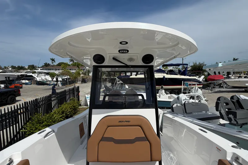 Slide: The Image of 2027 Sea Pro 262 DLX boat with sleek design, docked at a marina under clear skies. - 11