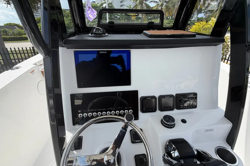 Slide: The Image of 2027 Sea Pro 262 DLX boat dashboard with steering wheel and electronic controls. - 28