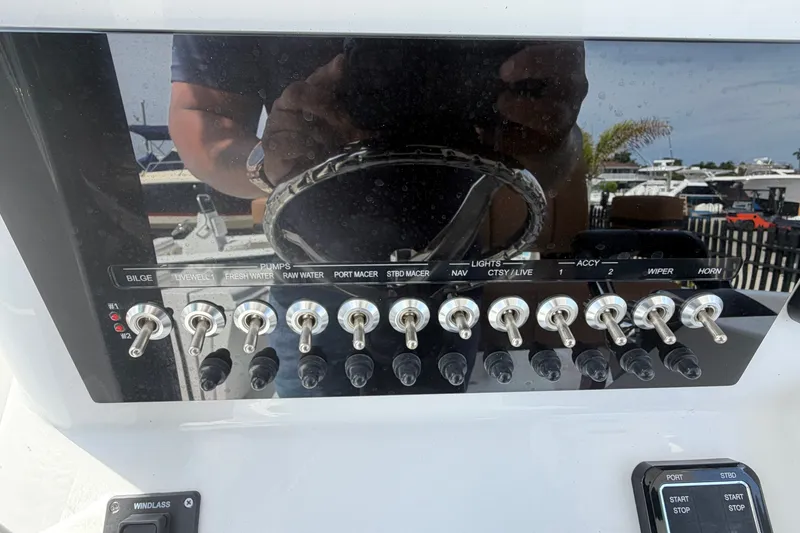 Slide: The Image of Control panel of a 2027 Sea Pro 262 DLX boat with various switches. - 30