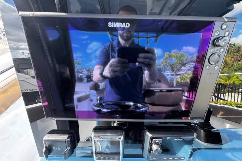 Slide: The Image of Simrad display on 2026 Sea Pro 292 DLX boat, reflecting a person and outdoor scenery. - 19