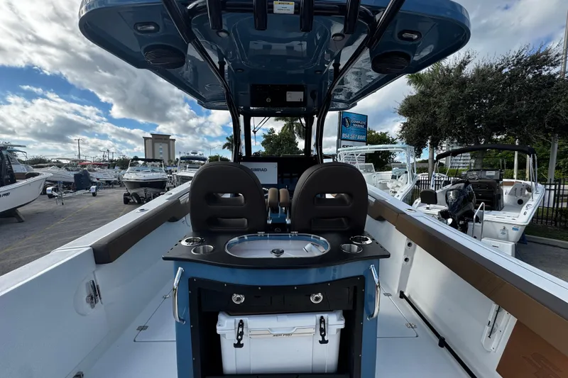Slide: The Image of 2026 Sea Pro 292 DLX boat interior with seating and console, docked under a cloudy sky. - 4