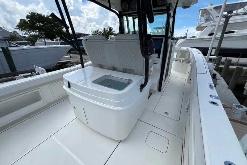 Slide: The Image of 2027 World Cat 325 CC boat interior with seating and storage, docked at marina. - 15