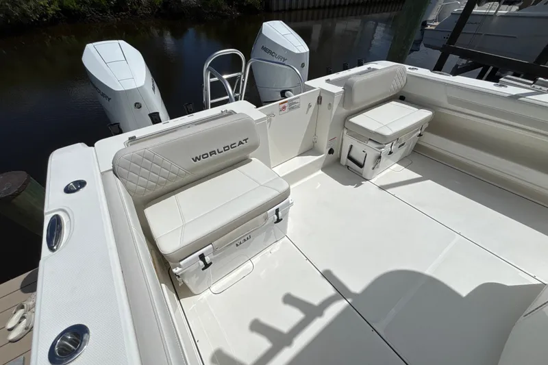 Slide: The Image of 2027 World Cat 325 CC boat interior with white seating and dual Mercury engines. - 18