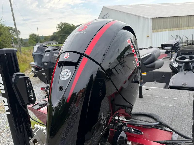 Slide: The Image of A black outboard motor with red stripes is attached to a boat on a trailer. - 20