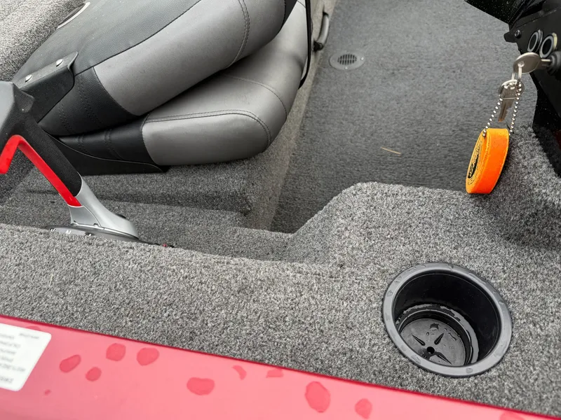 Slide: The Image of Close-up of a boat interior with gray carpet, a black cup holder, and a seat. - 16