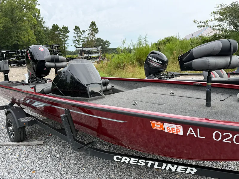 The Image of A red 2022 Crestliner CXF 189 boat sits on a trailer in a gravel lot. - 1