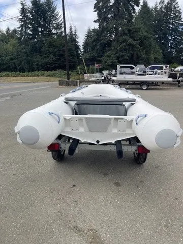 Slide: The Image of A Zodiac Nomad Rib Alu 2.7 boat on a trailer, surrounded by trees and other boats. - 5