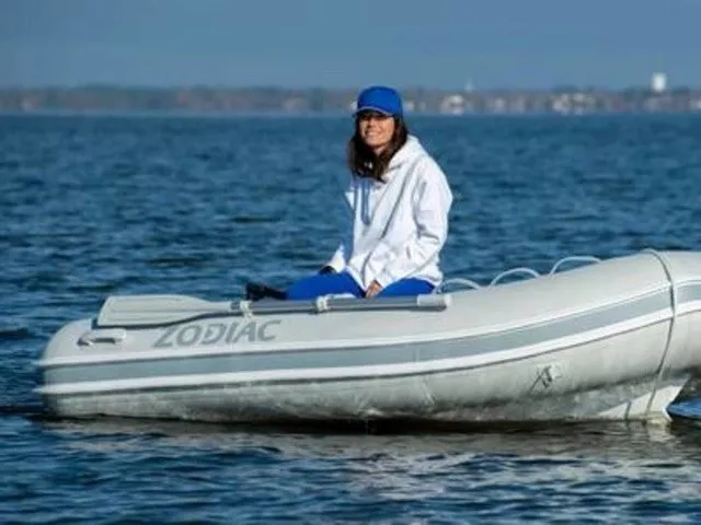 Slide: The Image of A person sits in a Zodiac Nomad Rib Alu 2.7 inflatable boat on calm water. - 23