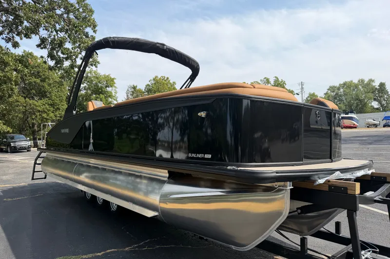 Slide: The Image of 2027 Harris Sunliner 250 pontoon boat with sleek black design on a trailer. - 5