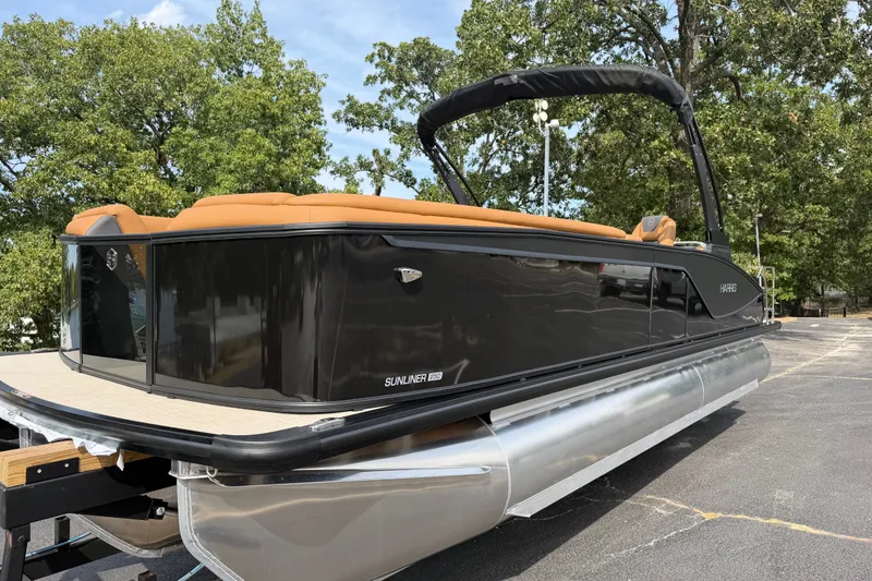 Slide: The Image of 2027 Harris Sunliner 250 pontoon boat with sleek black design and tan seating. - 3