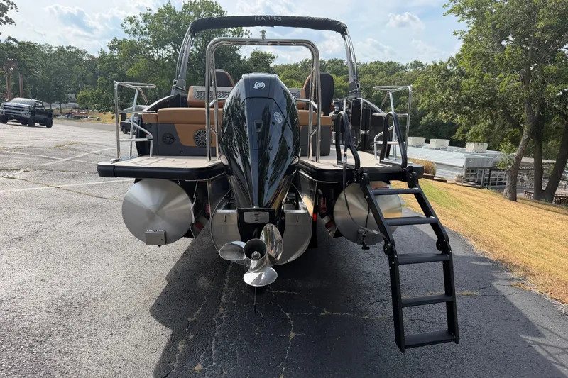 Slide: The Image of 2027 Harris Sunliner 250 pontoon boat with outboard motor and ladder, parked on asphalt. - 8