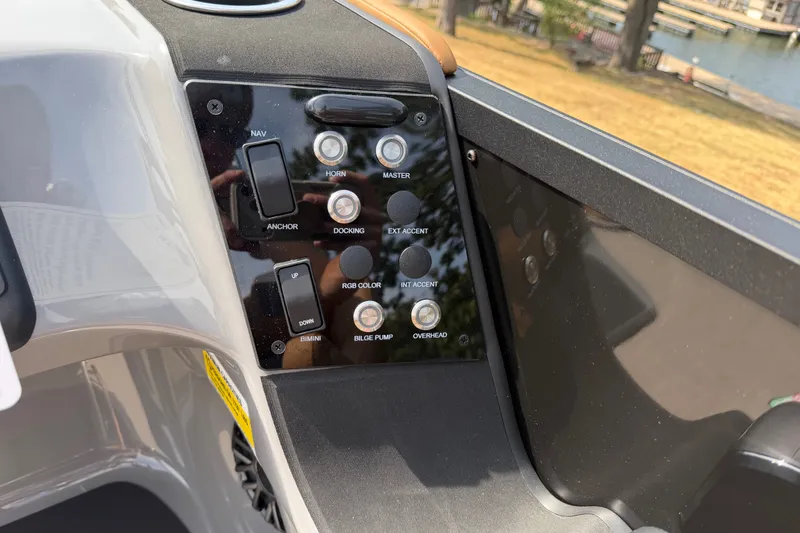 Slide: The Image of Control panel of 2027 Harris Sunliner 250 boat with various switches and buttons. - 11