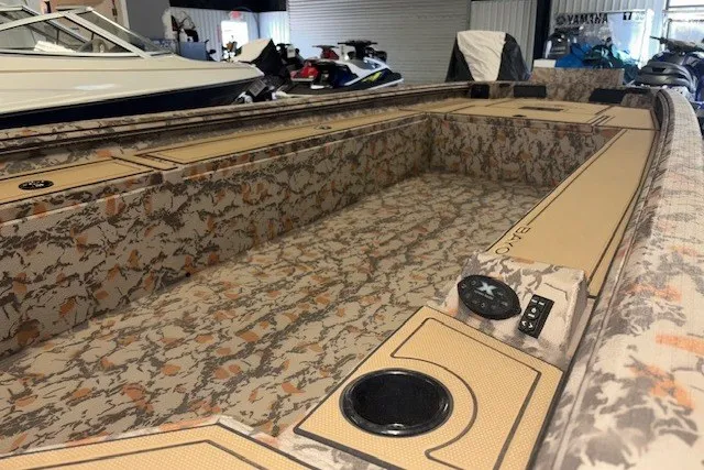 Slide: The Image of 2026 Xpress Bayou 180 boat interior with camouflage design in showroom. - 15