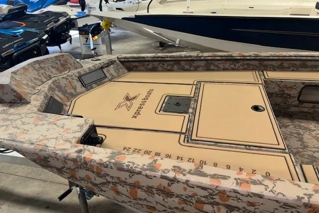 Slide: The Image of 2026 Xpress Bayou 180 boat interior with camouflage design and storage compartments. - 13
