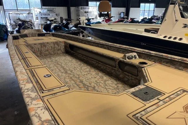 Slide: The Image of 2026 Xpress Bayou 180 boat interior with camouflage design in showroom. - 12
