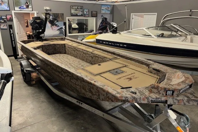 The Image of 2026 Xpress Bayou 180 boat with camouflage design in a showroom. - 1