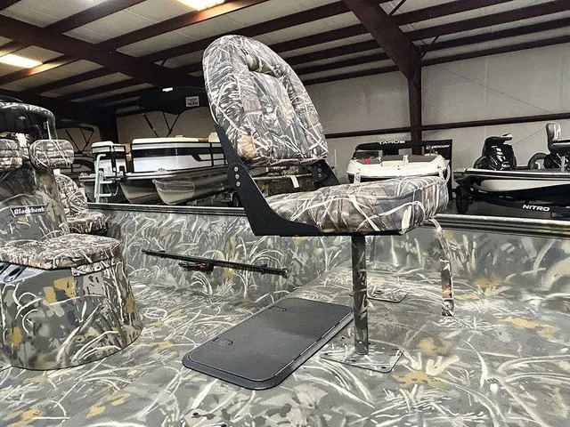 Slide: The Image of A War Eagle 2170 Blackhawk boat with camo-patterned seats in a storage facility. - 6