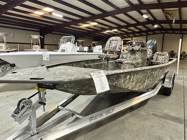 The Image of War Eagle 2170 Blackhawk 2027 in a warehouse, featuring camouflage pattern and trailer. - 1