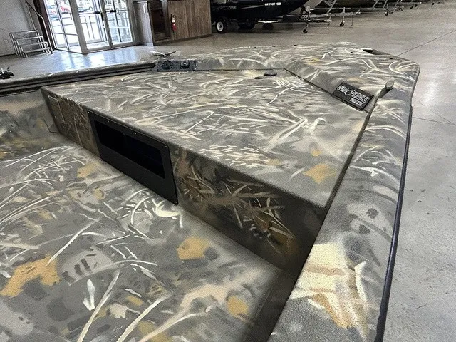 Slide: The Image of The boat features a camouflage paint job and is situated in a showroom. - 5