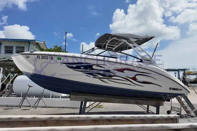 The Image of A 2023 Yamaha 252SD boat on a trailer, featuring a sleek design and a sunshade. - 1