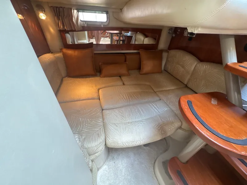 Slide: The Image of Interior of the 2006 Four Winns 318 Vista with beige upholstered sofa and wooden table. - 14
