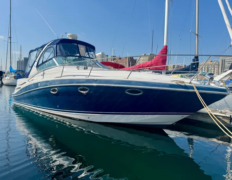 The Image of A 2006 Four Winns 318 Vista is docked in the water, surrounded by other boats in the marina. - 0