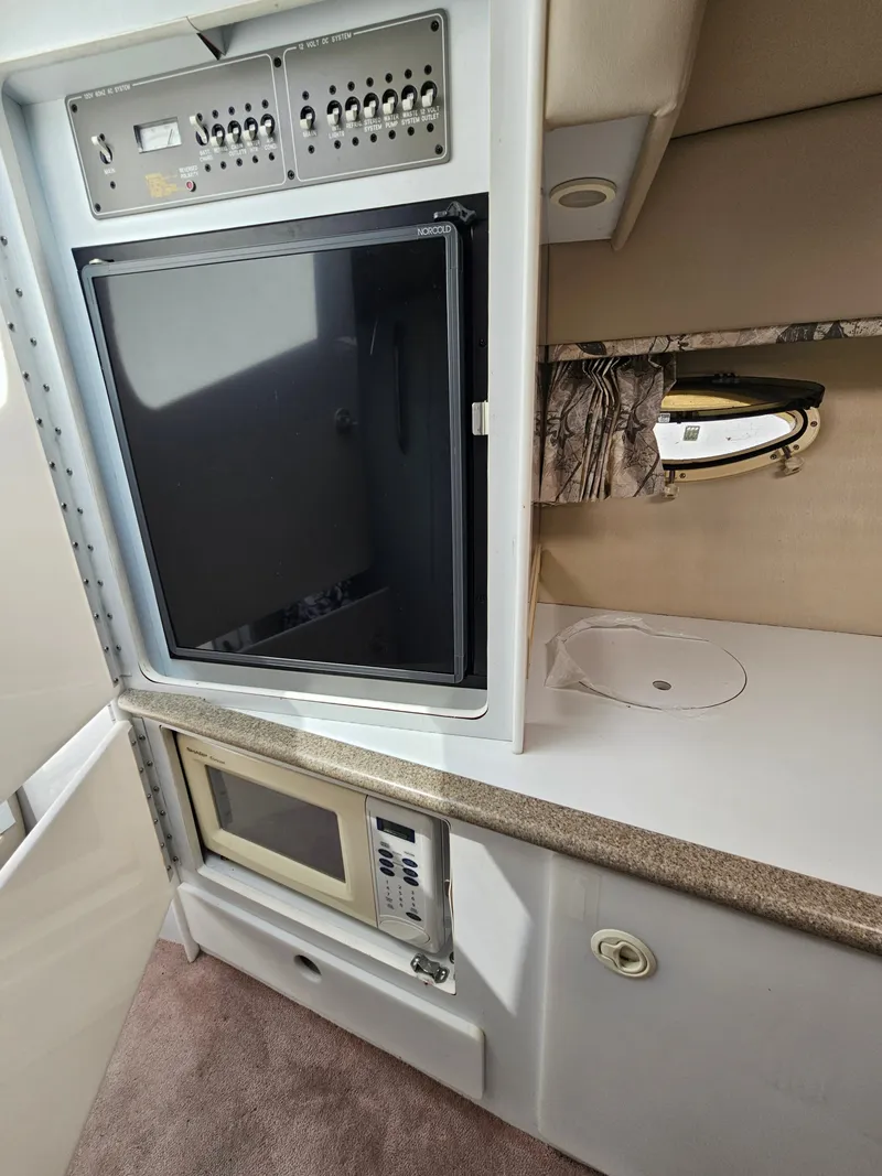 Slide: The Image of Interior of a 1998 Formula 330 Sun Sport with a fridge, microwave, and storage space. - 13