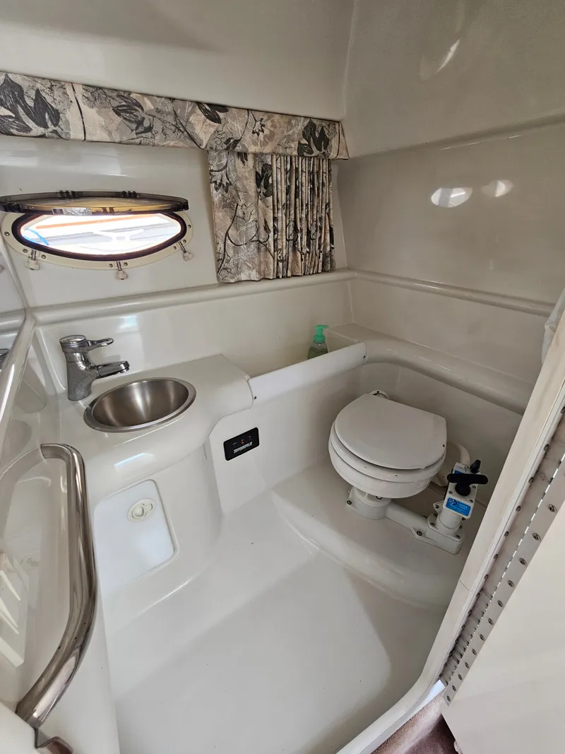 Slide: The Image of The image shows a clean boat bathroom with a sink, toilet, and small window. - 14